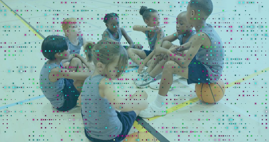 Youth basketball team sitting in circle on gym floor discussing game plan during practice