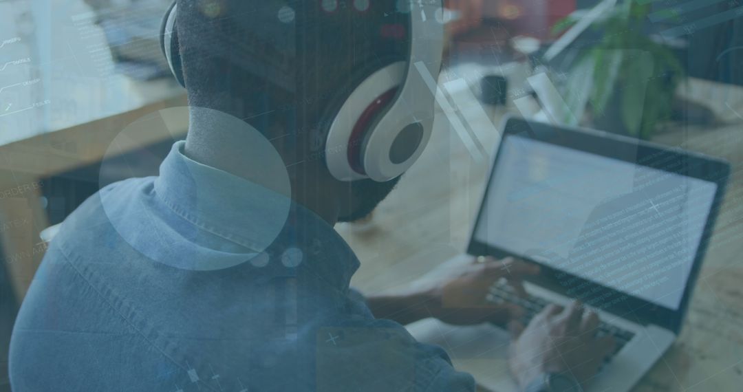 Person with Headphones Analyzing Data on Laptop Display