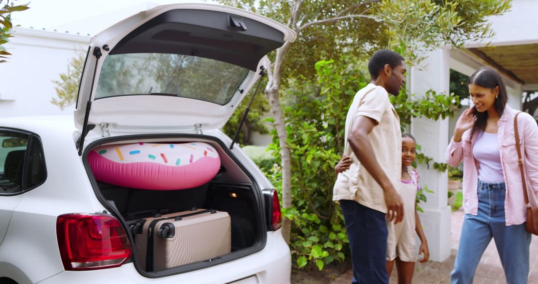 Family Unloading Luggage and Inflatable Float from Car for Vacation