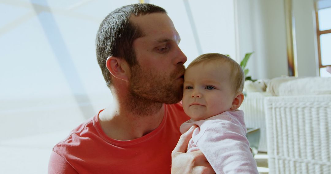 Father Holding and Kissing Baby Girl in Bright Living Room - Free Images, Stock Photos and Pictures on Pikwizard.com