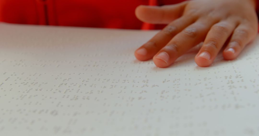 Child Reading Braille Book with Hand Touching Text