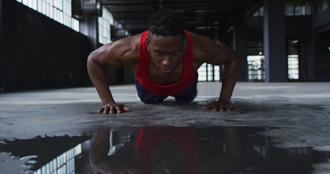 Determined Man Performing Push-Ups in Dark Warehouse - Free Images, Stock Photos and Pictures on Pikwizard.com