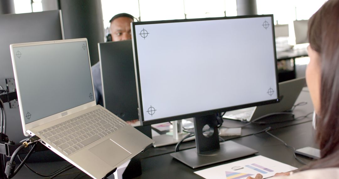 Business Professional Multitasking with Laptop and Monitor