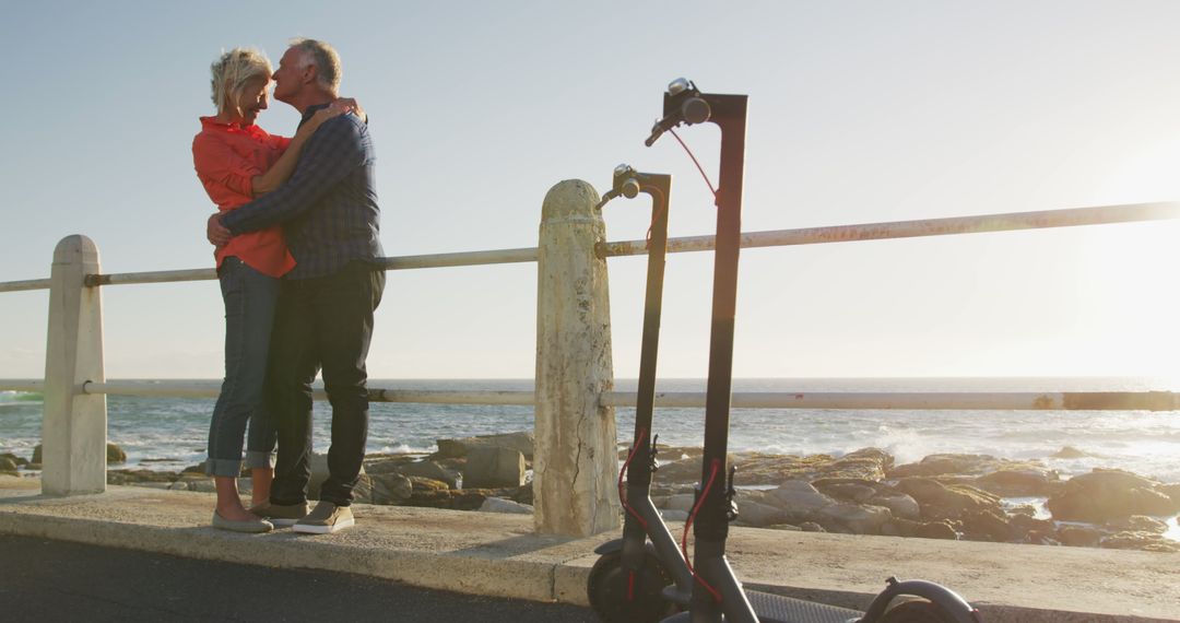 Senior Couple Embracing on Sunny Seafront Promenade with Scooters