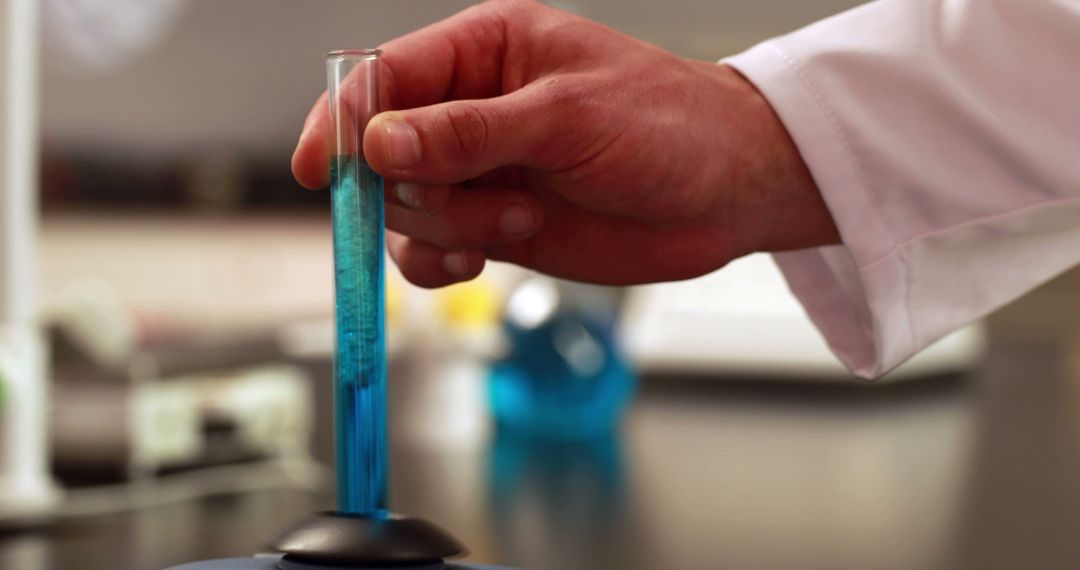 Scientist conducting chemical experiment with blue liquid in laboratory - Free Images, Stock Photos and Pictures on Pikwizard.com