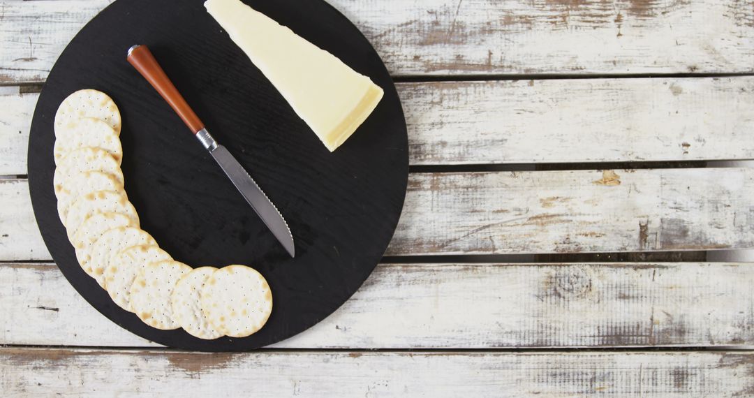 Round Cutting Board with Cheese and Crackers on Rustic Wooden Table - Free Images, Stock Photos and Pictures on Pikwizard.com