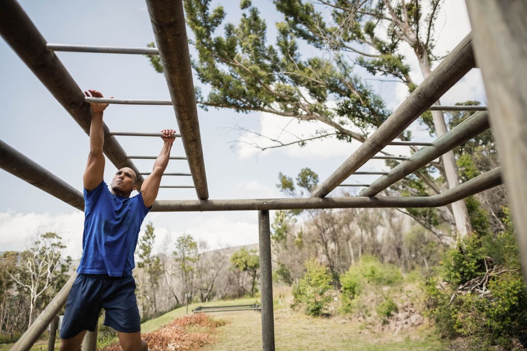 Man Traversing Monkey Bars on Outdoor Obstacle Course