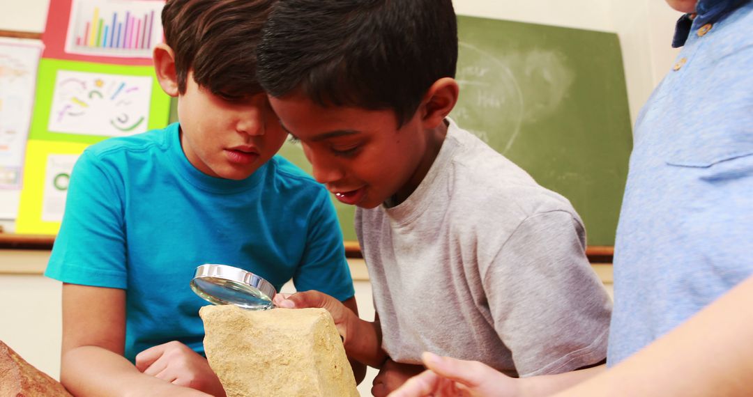 Curious Boys Examining Rock with Magnifying Glass in Classroom - Free Images, Stock Photos and Pictures on Pikwizard.com