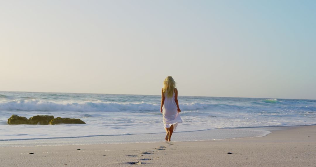 Serenity at Sunset: Woman Strolling along Tranquil Beachscape