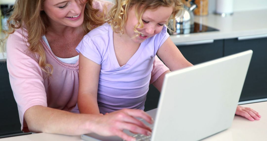 Mother and Daughter Using Laptop in Bright Modern Kitchen - Free Images, Stock Photos and Pictures on Pikwizard.com