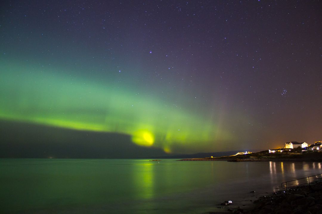 Northern Lights Over Tranquil Coastal Village at Night - Free Images, Stock Photos and Pictures on Pikwizard.com