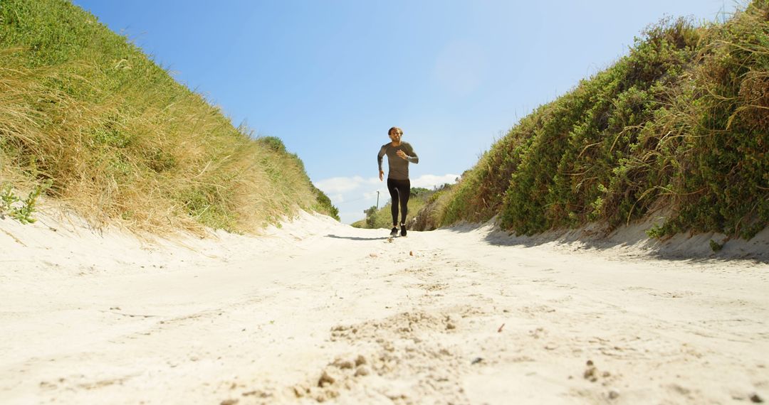 Man Jogging on Sandy Path Between Greenery under Blue Sky - Free Images, Stock Photos and Pictures on Pikwizard.com