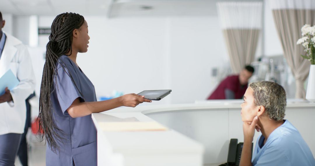 Nurse Talking to Colleague at Hospital Reception Desk - Free Images, Stock Photos and Pictures on Pikwizard.com