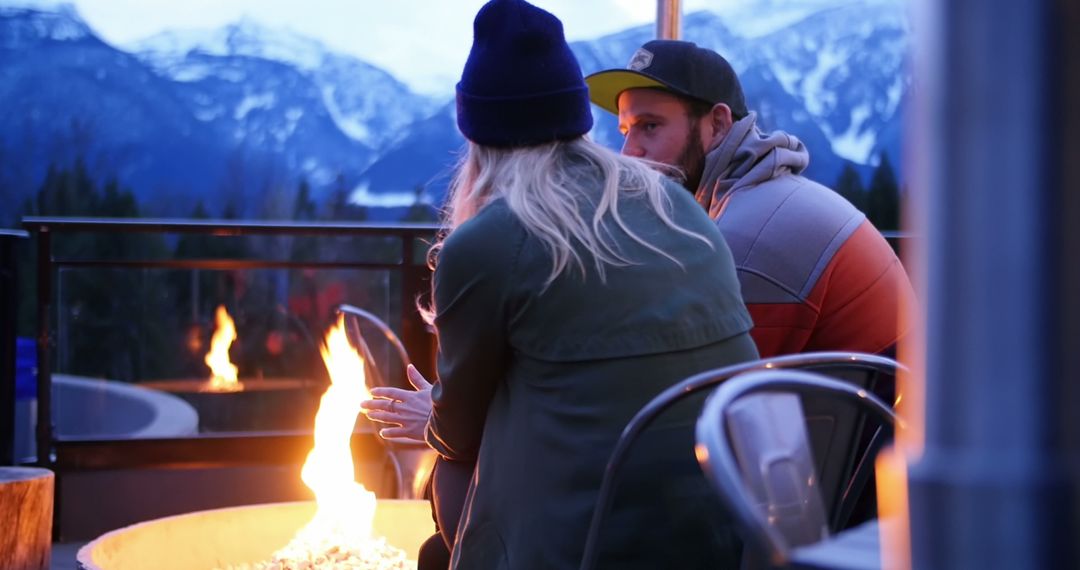 A couple shares a romantic embrace by a fire pit against a scenic mountain landscape. - Free Images, Stock Photos and Pictures on Pikwizard.com