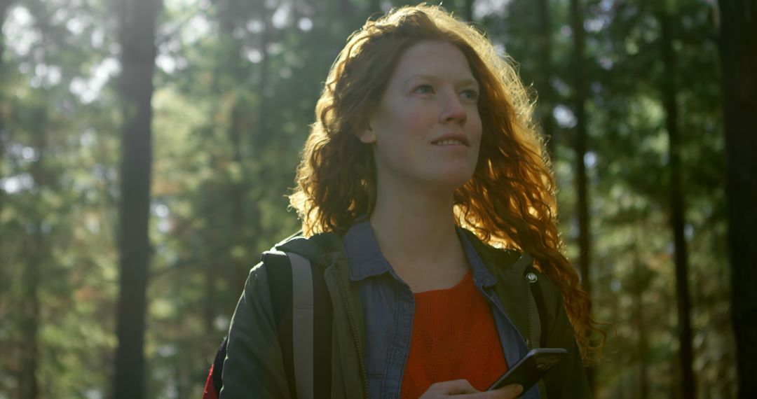 Young Woman Exploring Forest with Smartphone in Sunlit Environment - Free Images, Stock Photos and Pictures on Pikwizard.com