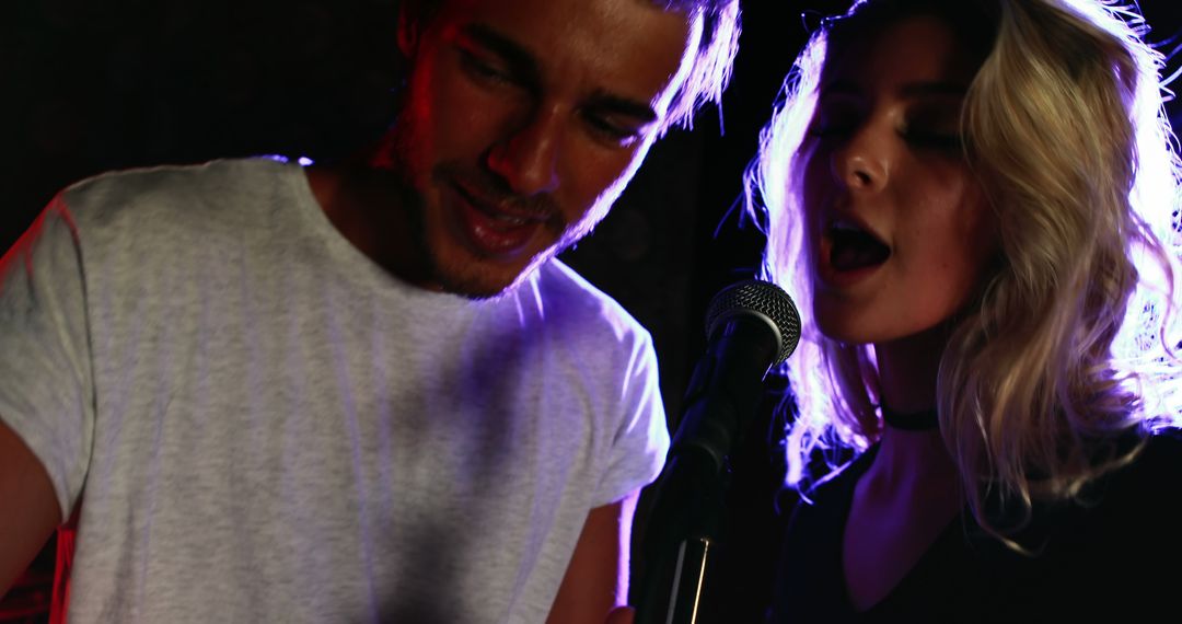 Young Musicians Singing Together on Stage Under Spotlight - Free Images, Stock Photos and Pictures on Pikwizard.com