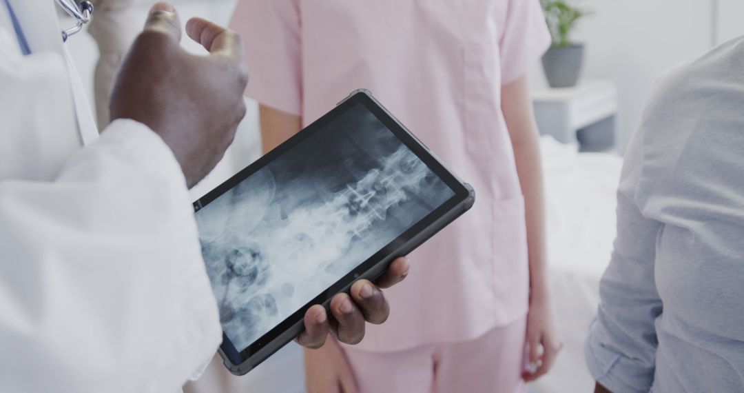 Healthcare Professionals Analyzing X-ray on Tablet in Hospital Room - Free Images, Stock Photos and Pictures on Pikwizard.com