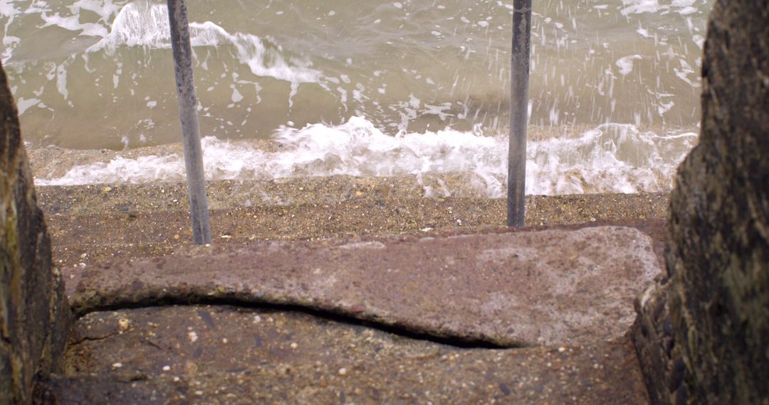 Waves Crashing Against Seaside Pier with Iron Railing - Free Images, Stock Photos and Pictures on Pikwizard.com