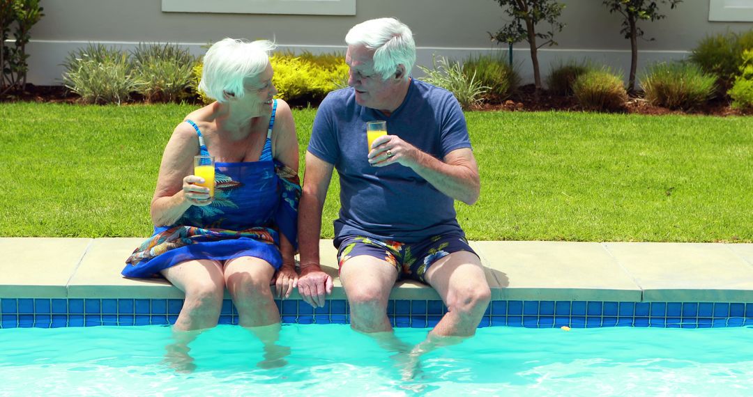 Senior Couple Relaxing by Poolside Holding Drinks and Enjoying Summer - Free Images, Stock Photos and Pictures on Pikwizard.com