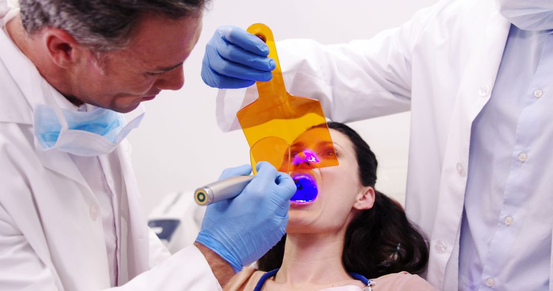 Dentists Using UV Light for Dental Treatment on Female Patient - Free Images, Stock Photos and Pictures on Pikwizard.com