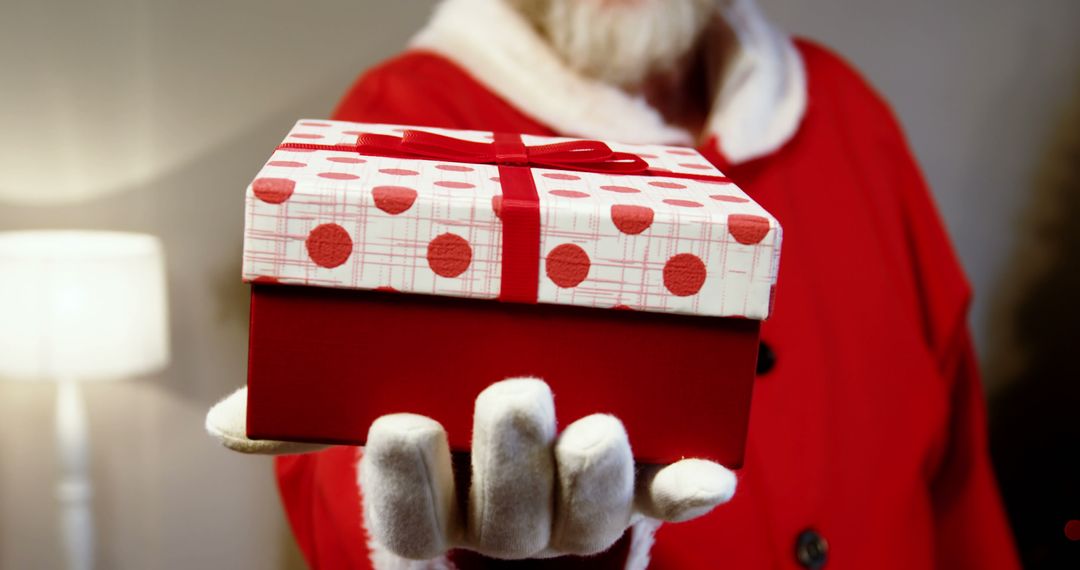 Santa Claus Holding Gift Box Wrapped in Red and White Paper - Free Images, Stock Photos and Pictures on Pikwizard.com