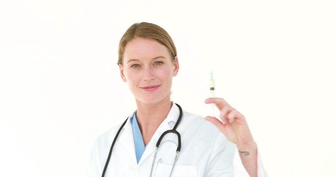 Confident Female Doctor Holding Syringe in Medical Setting - Free Images, Stock Photos and Pictures on Pikwizard.com