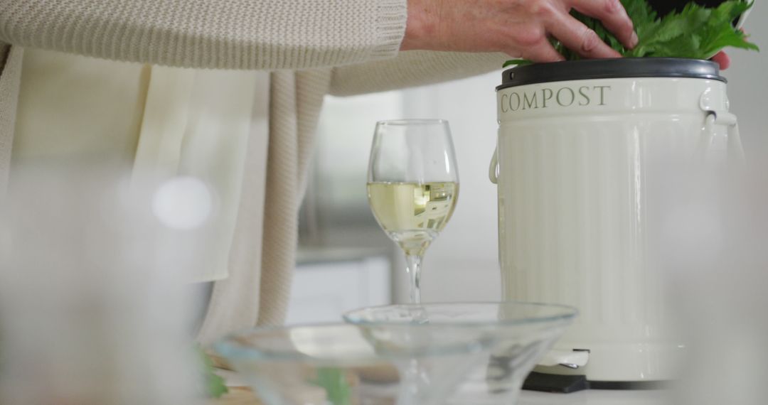 A senior woman enjoys retirement by composting and sipping wine in her kitchen. - Free Images, Stock Photos and Pictures on Pikwizard.com