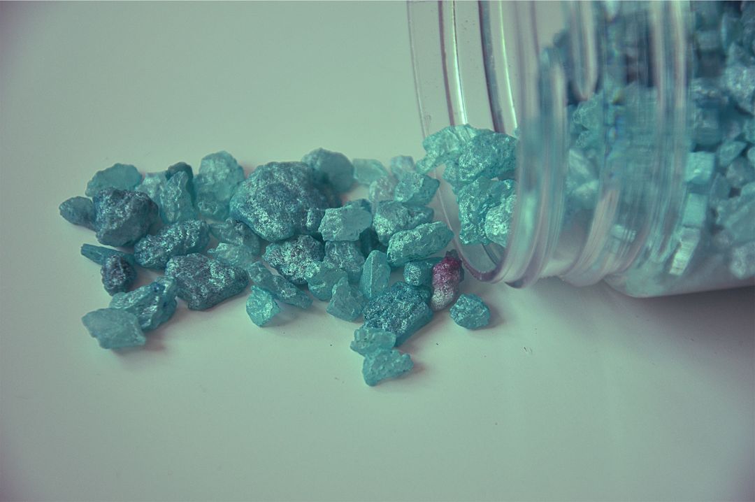 Top View of Blue Crystal Stones Scattered from Jar