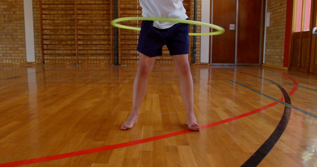 Child Enjoying Hula Hoop in School Gymnasium