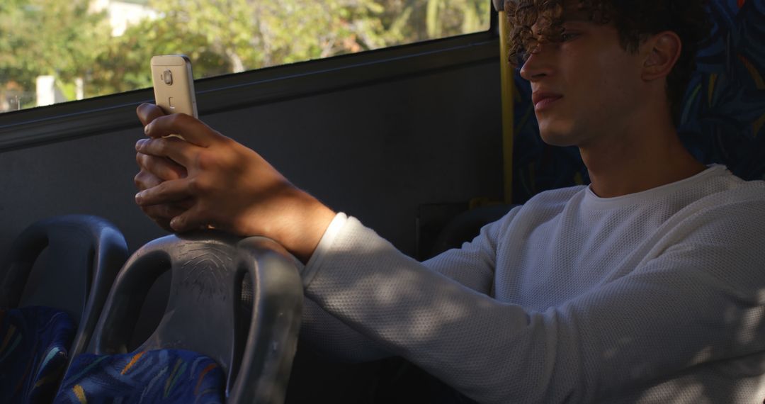 Young Man Sitting On Bus Using Smartphone During Day - Free Images, Stock Photos and Pictures on Pikwizard.com