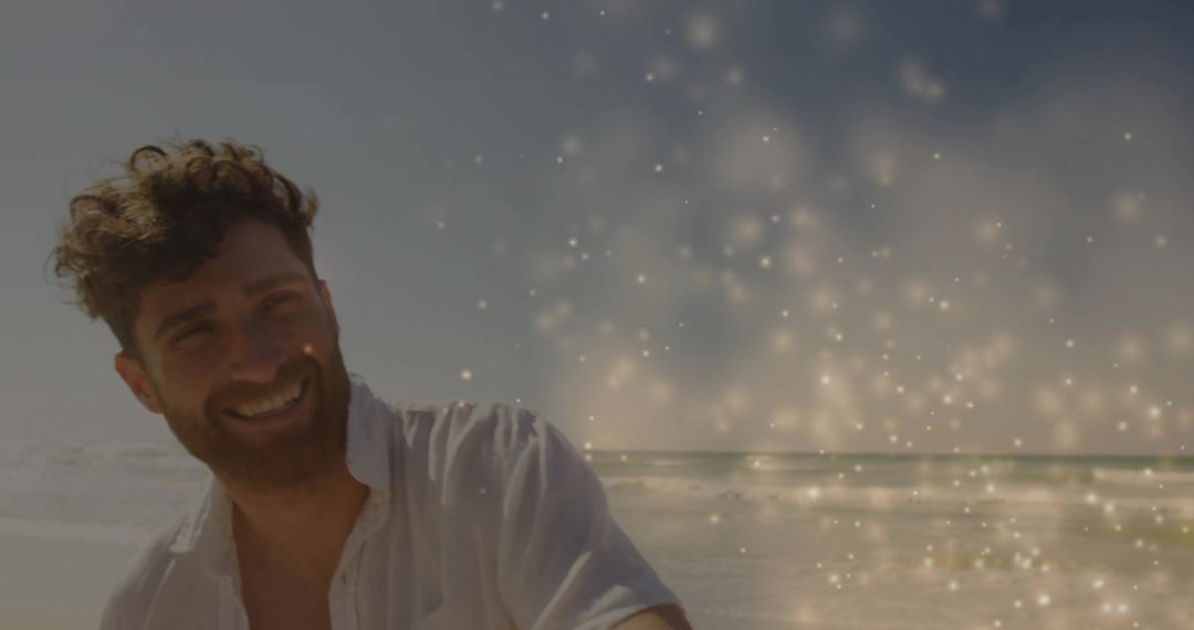 Man with Beard Smiling by Sunny Beach with Sparkling Lights