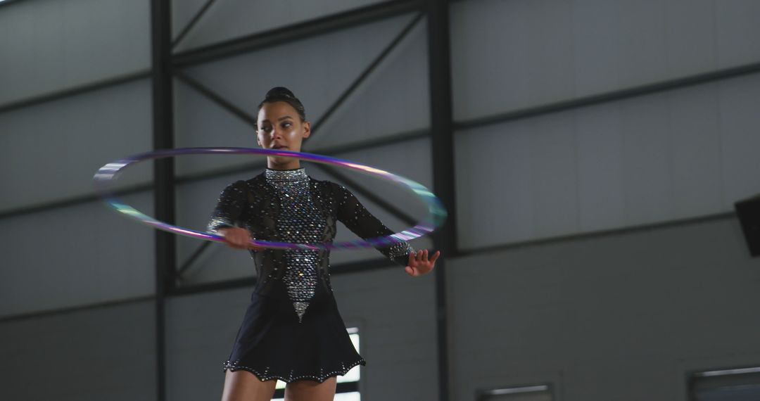 Rhythmic Gymnast Performs with Hula Hoop in Indoor Arena - Free Images, Stock Photos and Pictures on Pikwizard.com