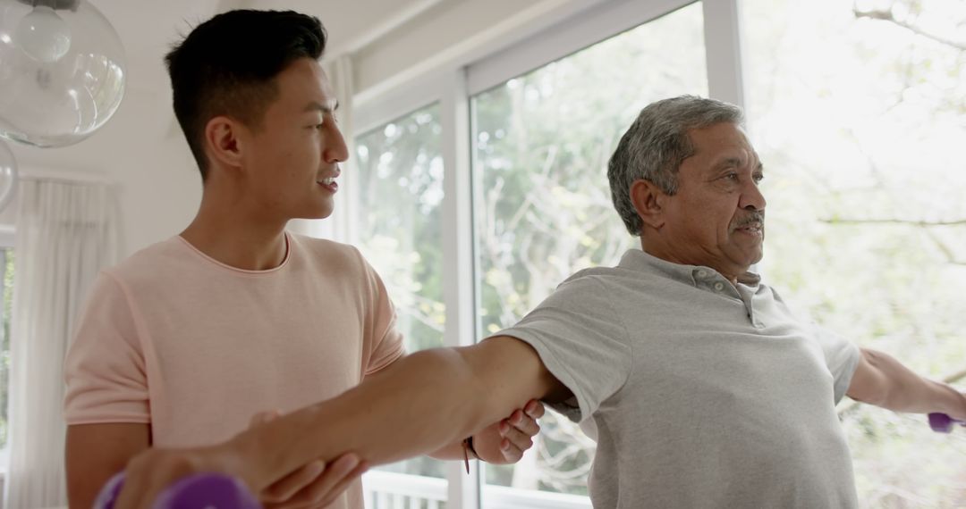 Physiotherapist Assists Senior Man in Dumbbell Workout
