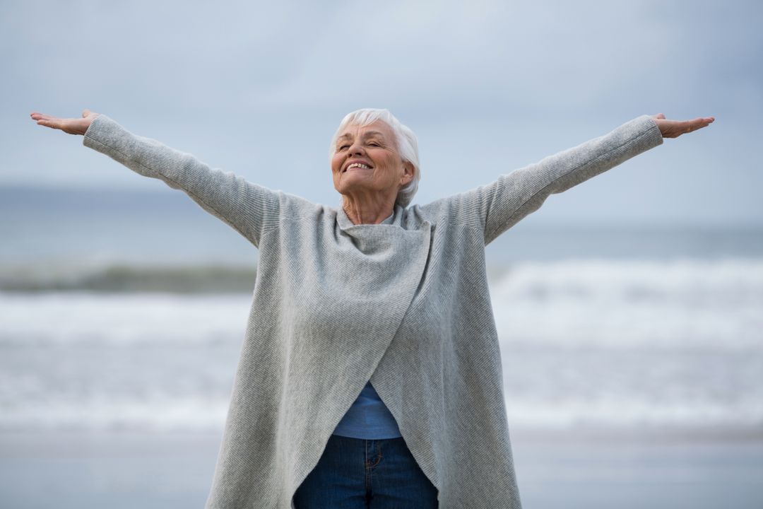 Joyful Senior Woman Embracing Life at the Beach - Free Images, Stock Photos and Pictures on Pikwizard.com