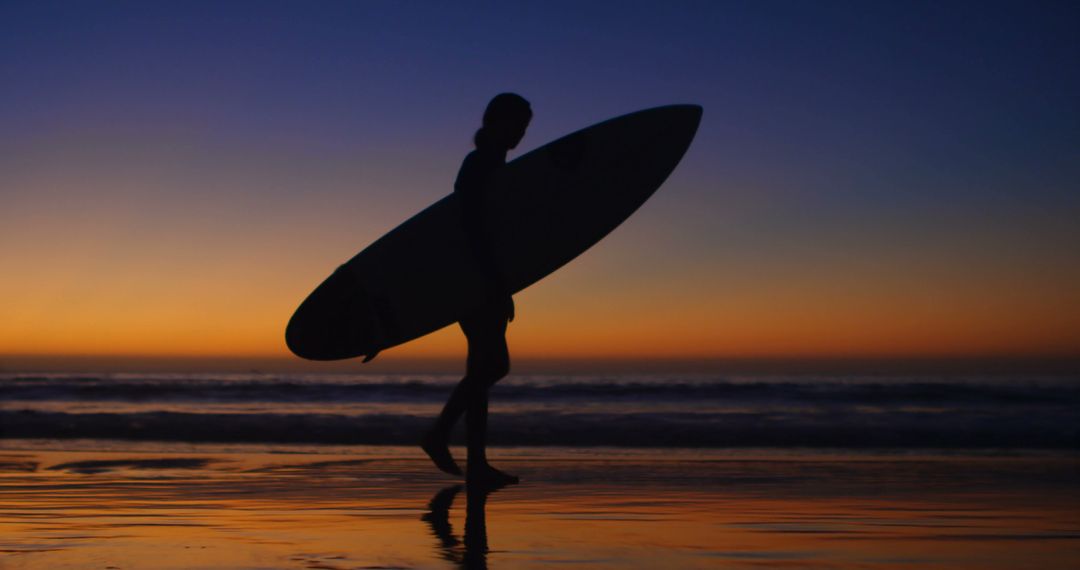 Silhouette of Surfer Holding Board on Beach at Sunset - Free Images, Stock Photos and Pictures on Pikwizard.com