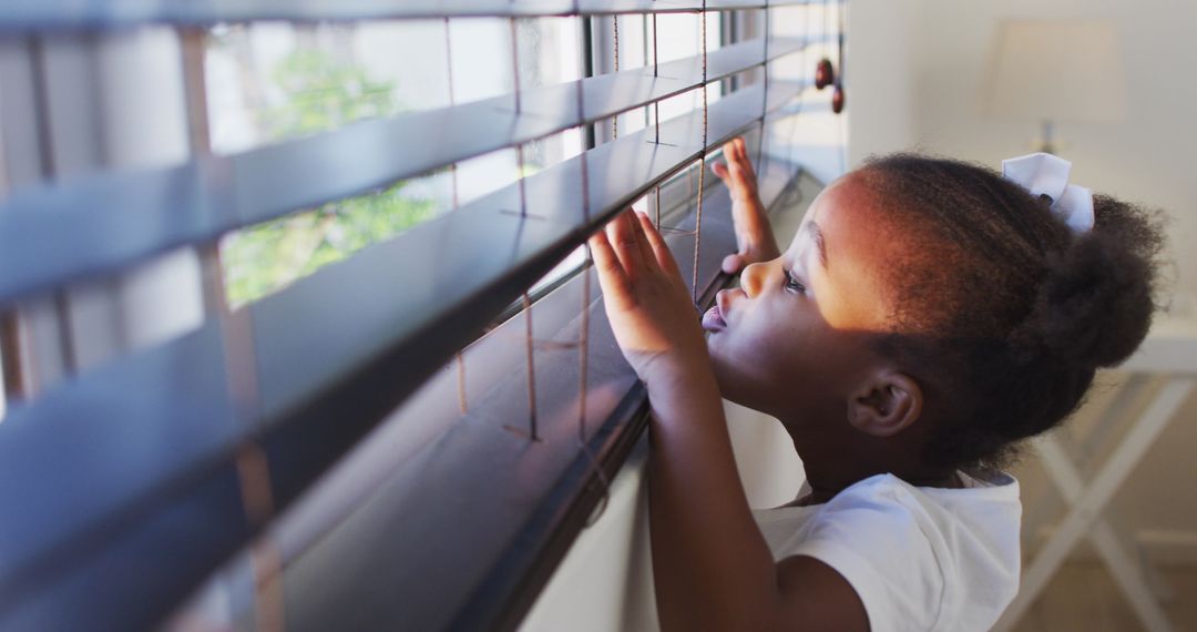 Curious Girl Peering Through Window Blinds at Home