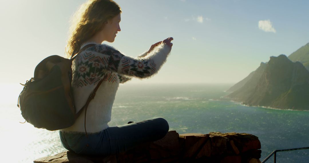 Young Woman Taking Photo at Coastal Cliff with Backpack - Free Images, Stock Photos and Pictures on Pikwizard.com