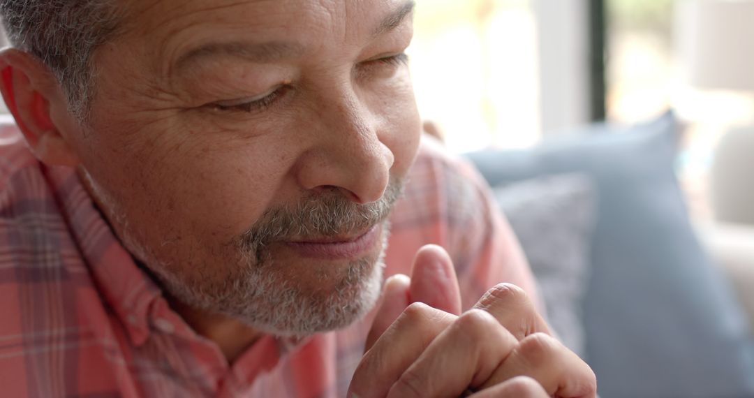 Senior Man Praying at Home with Eyes Closed and Hands Clasped - Free Images, Stock Photos and Pictures on Pikwizard.com