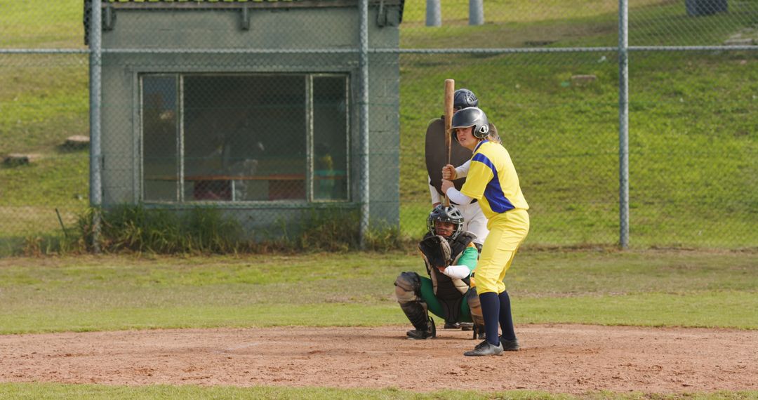 Female Softball Player Batting in Competitive Game Setting