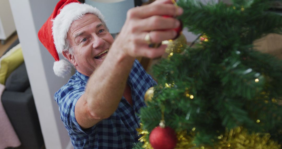 Senior Man Decorating Christmas Tree with Santa Hat - Free Images, Stock Photos and Pictures on Pikwizard.com