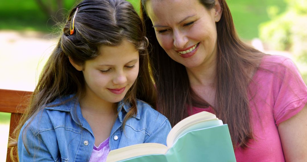 Mother and Daughter Reading Together on Park Bench
