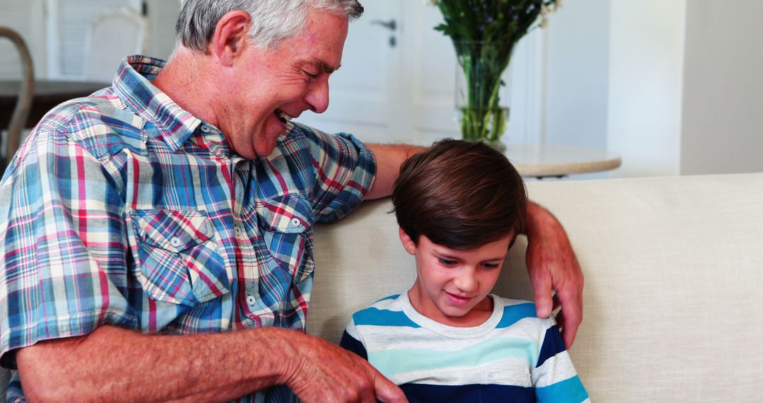 Grandfather Sharing Quality Time with Grandson Sitting on Couch - Free Images, Stock Photos and Pictures on Pikwizard.com