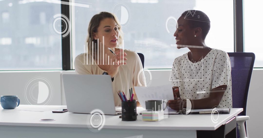 Diverse Female Colleagues Analyzing Data in Modern Office