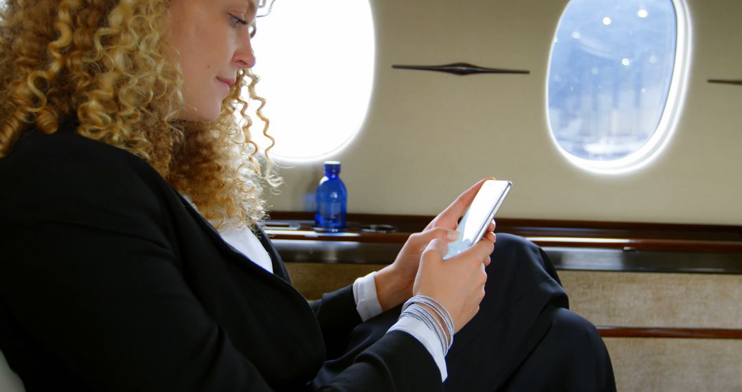 Businesswoman Checking Phone on Private Jet with Copy Space