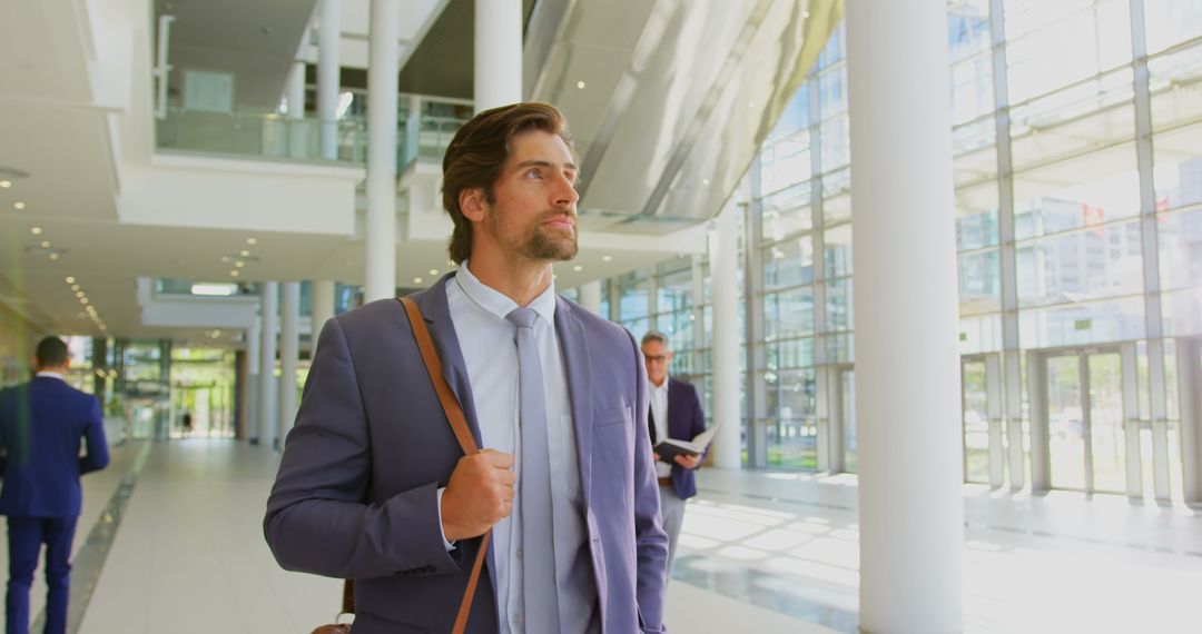 Confident Businessman Walking Through Modern Office Lobby