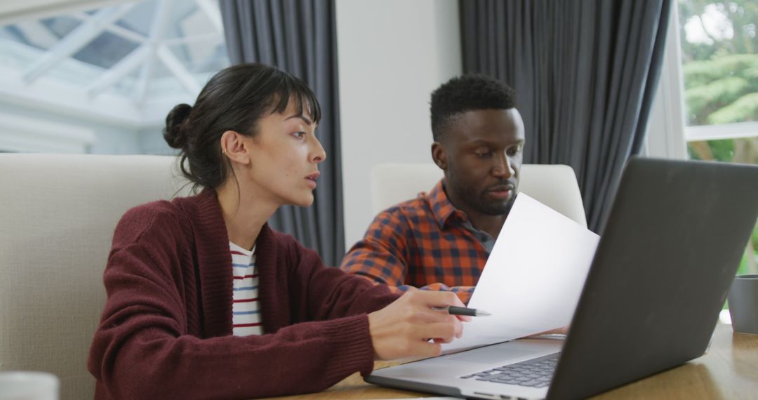 Diverse Couple Collaborating on Laptop at Home