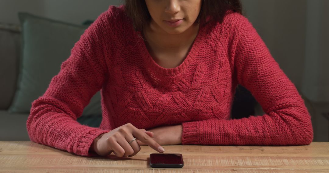 Young Woman Using Smartphone at Wooden Table in Dimly Lit Room - Free Images, Stock Photos and Pictures on Pikwizard.com