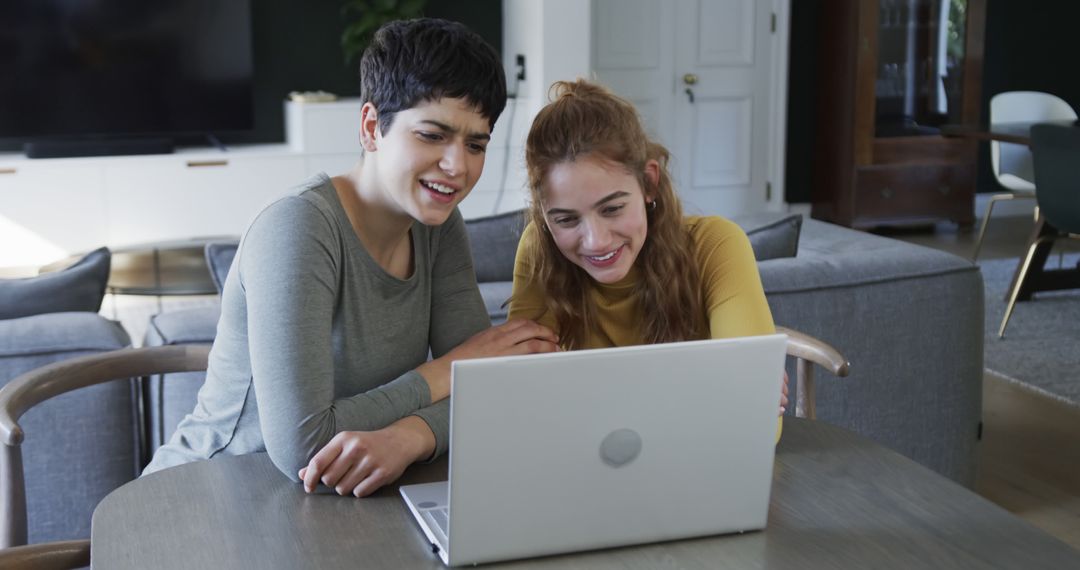 Young Women Smiling While Looking at Laptop at Home - Free Images, Stock Photos and Pictures on Pikwizard.com