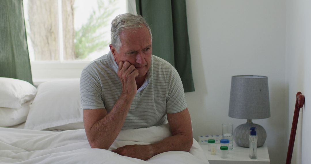 Elderly Man Sitting on Bed Contemplating in Bright Bedroom - Free Images, Stock Photos and Pictures on Pikwizard.com