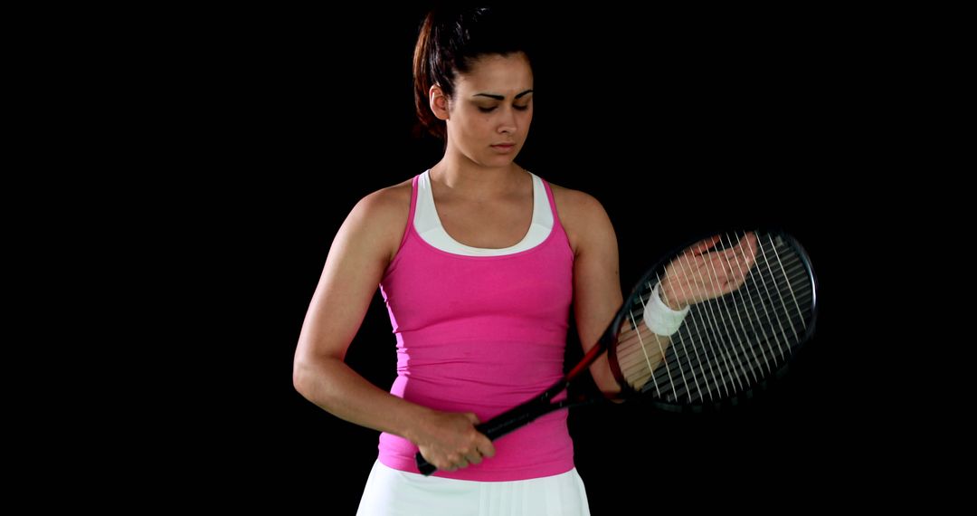 Female Tennis Player Adjusting Grip On Racket Against Black Background - Free Images, Stock Photos and Pictures on Pikwizard.com